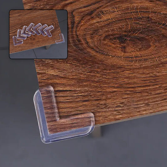 Close-up of a transparent silicone baby corner protector installed on a wooden table.