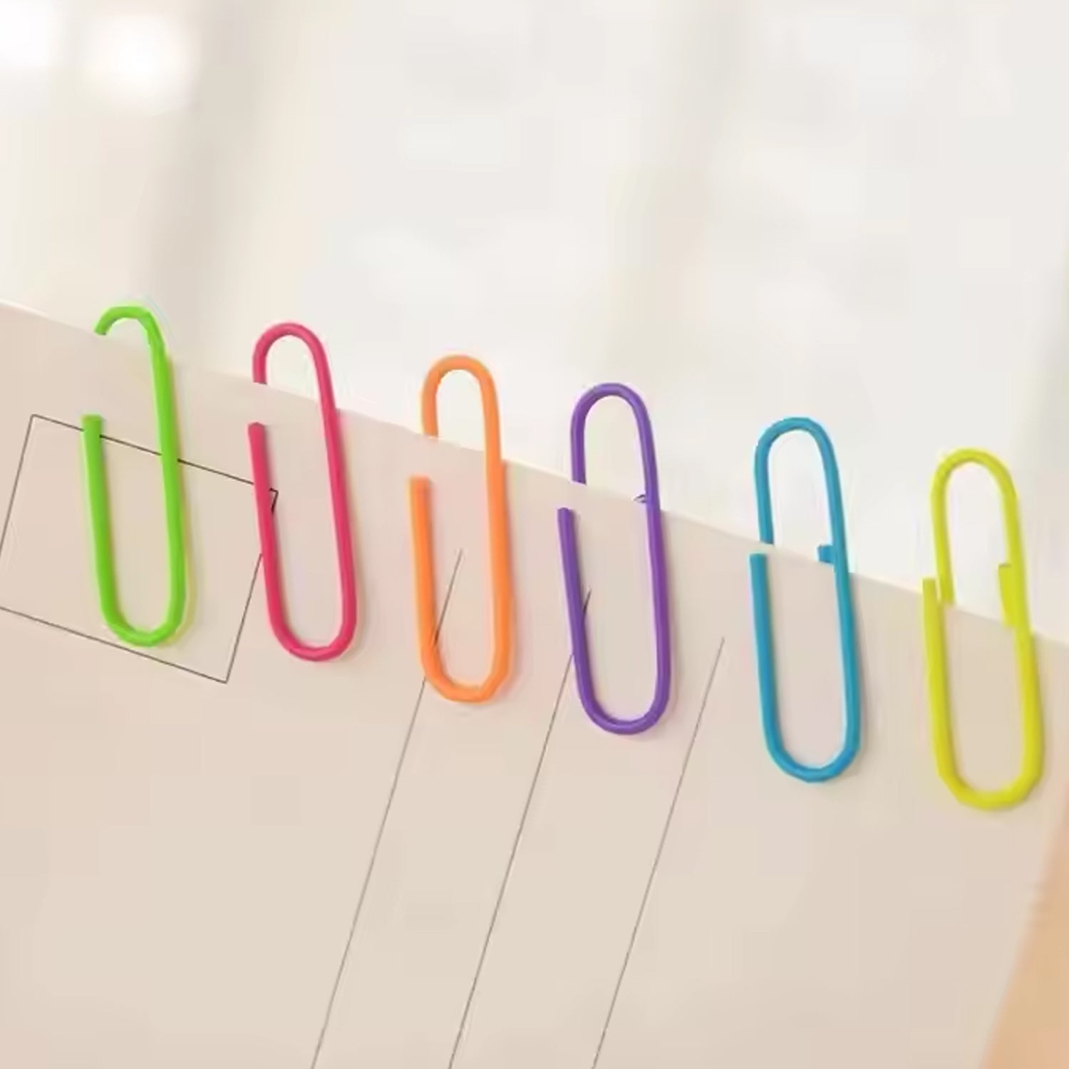 Assorted colored U-shape paper clips 28mm scattered on white background