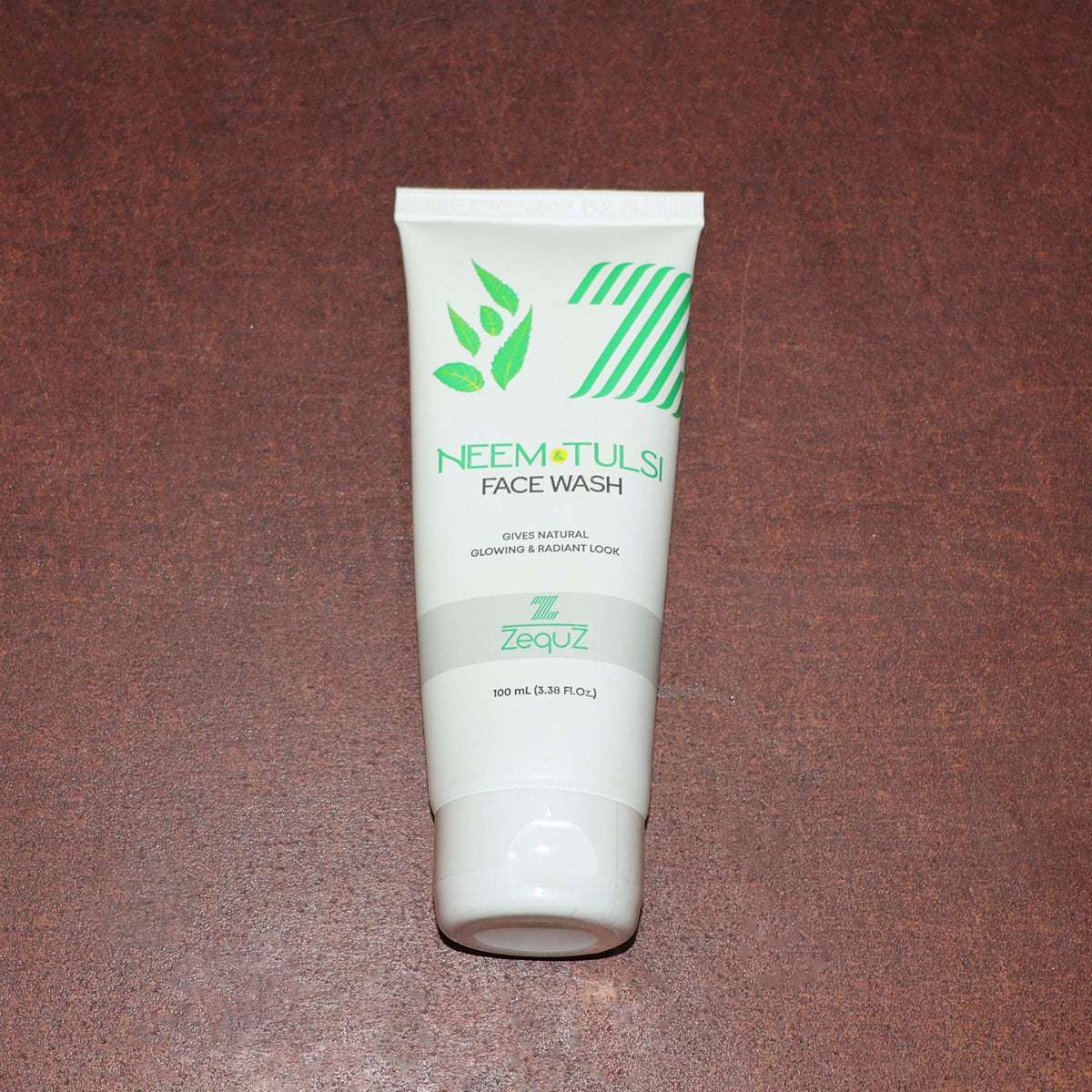 Zequz face wash tube with natural Neem and Tulsi leaves background
