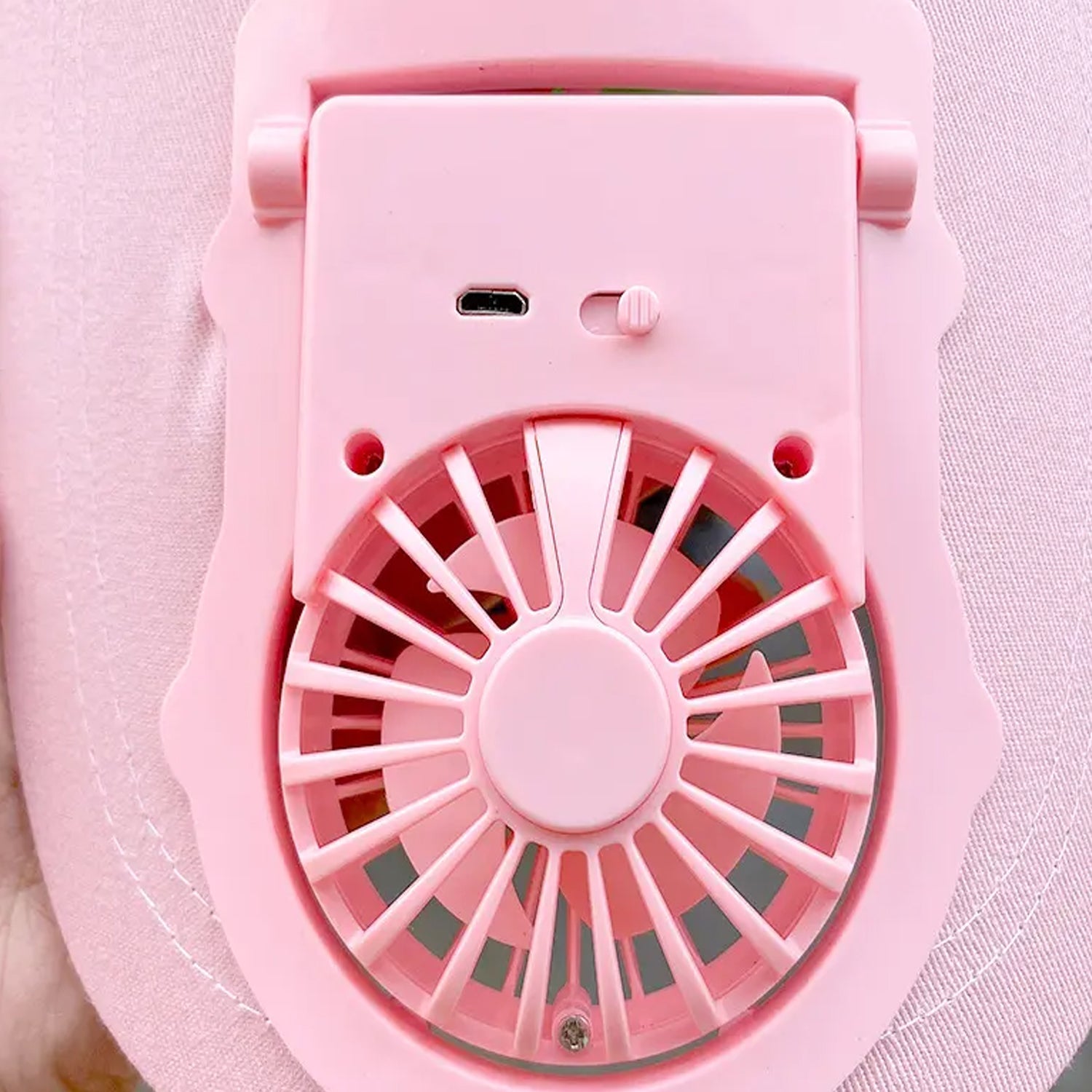 The USB rechargeable fan cap shown mounted on headwear, ready for outdoor use.