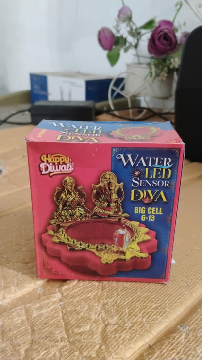 Close-up shot of golden LED pooja diya activated by water sensor