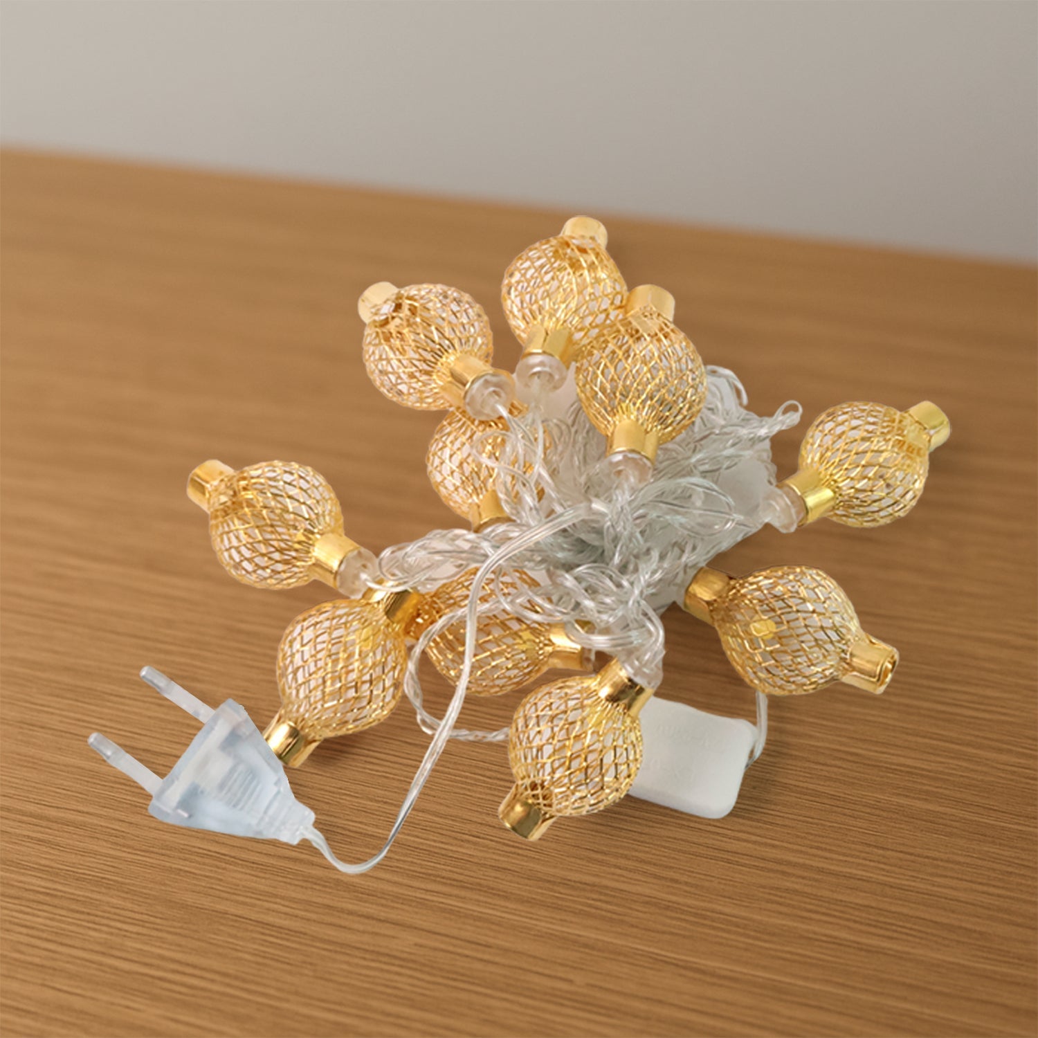 Intricate hollow metal ball LED string light casting warm festive glow