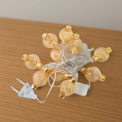 Intricate hollow metal ball LED string light casting warm festive glow