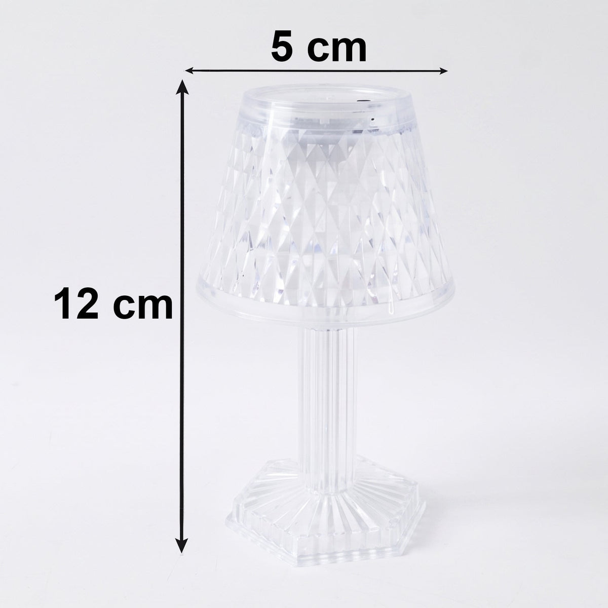 Small crystal table lamp creating a warm, ambient glow in a dark room.